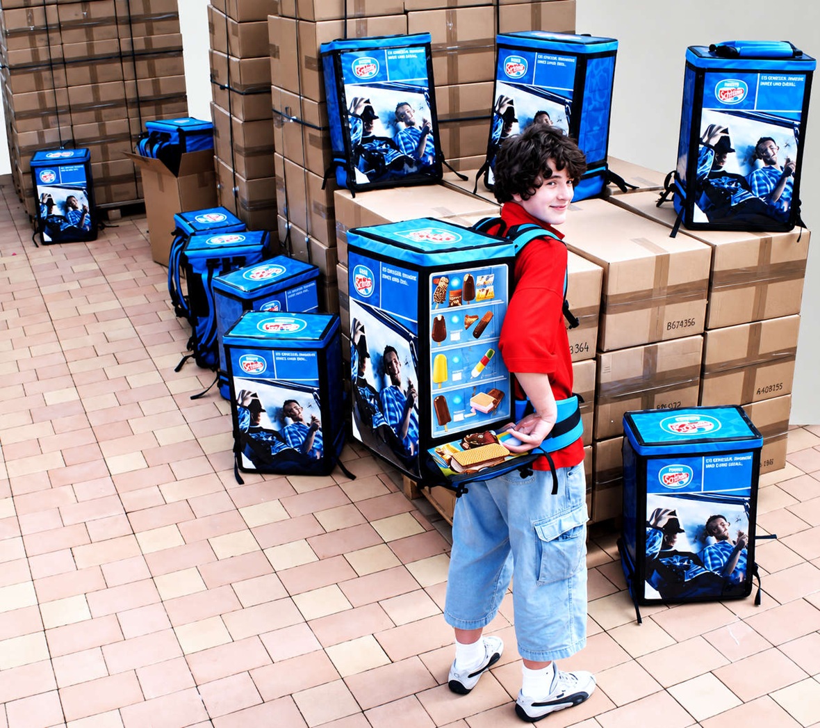 Multiple custom-branded can and bottle dispenser backpacks prepared for a large-scale promotional campaign with packaged ice cream products.